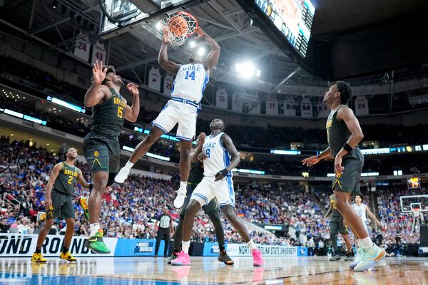 Duke guard Sion James dunks over Baylor forward Norchad Omier during the first half in the second round of the NCAA college basketball tournament, Sunday, March 23, 2025, in Raleigh, N.C. (AP Photo/Chris Carlson)