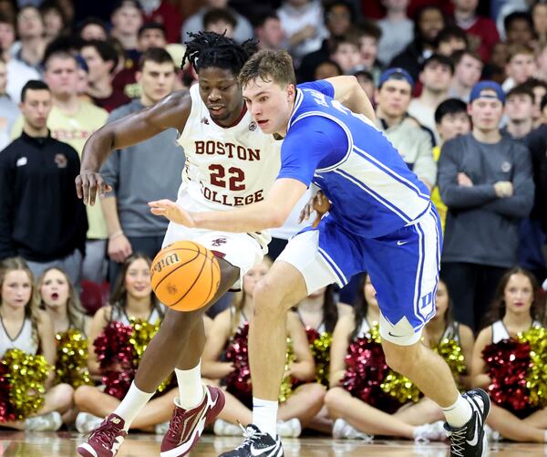 Boston College forward Jayden Hastings, left, and Duke guard Cooper Flagg, right, chase the ball during the first half of an NCAA college basketball game Saturday, Jan. 18, 2025, in Boston. (AP Photo/Mark Stockwell)