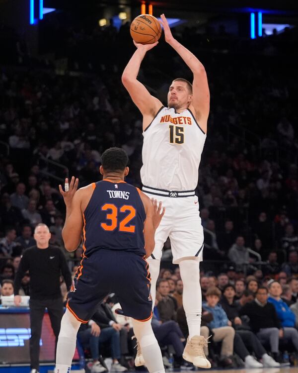 Denver Nuggets' Nikola Jokic (15) shoots over New York Knicks' Karl-Anthony Towns (32) during the second half of an NBA basketball game Wednesday, Jan. 29, 2025, in New York. (AP Photo/Frank Franklin II)