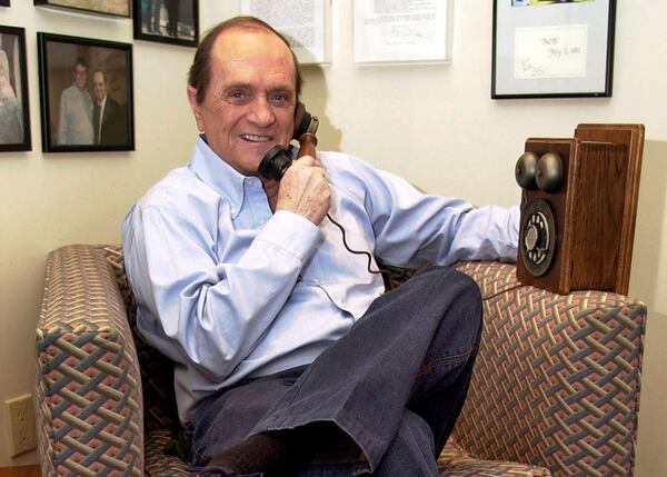 FILE - Comedian Bob Newhart pretends to speak on an antique telephone at his home in the Bel Air Estates community of Los Angeles, June 25, 2003. (AP Photo/Jerome T. Nakagawa, File)