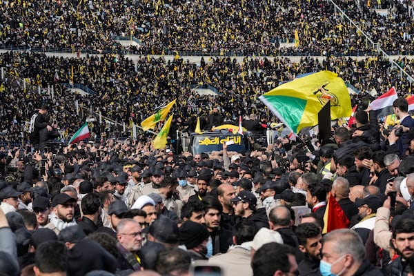 A trailer carrying the coffins containing the bodies of Hezbollah's former leader Hassan Nasrallah and his cousin and successor Hashem Safieddine drives through the crowd at the beginning of a funeral procession in the Sports City Stadium in Beirut, Lebanon, Sunday, Feb. 23, 2025. (AP Photo/Hussein Malla)