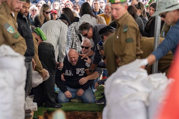 Nir, the father of Israeli soldier Sergeant Yahav Maayan who was killed in combat in the Gaza Strip, reacts next to his son's grave during his funeral at a military cemetery in Modiin, Israel, Sunday, Jan. 12, 2025. (AP Photo/Ohad Zwigenberg)