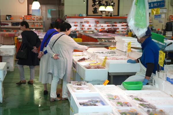 FILE - Visitors check seafood sold at the seafood market "Lalamew" near the Onahama fish port in Iwaki City, Fukushima Prefecture, on Oct. 19, 2023 in Iwaki, northeastern Japan. (AP Photo/Eugene Hoshiko, File)