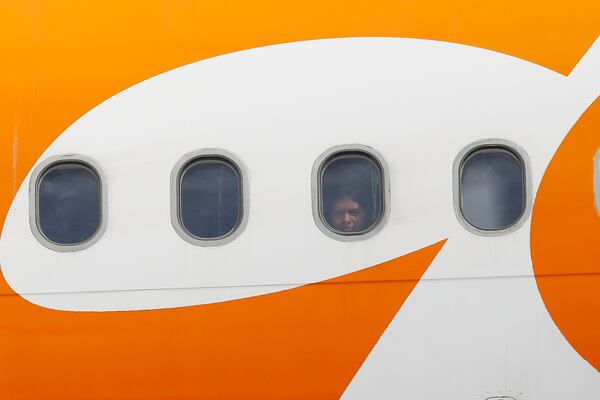 A migrant peers through the window of a plane carrying Venezuelan migrants deported from the United States after it landed at the Simon Bolivar International Airport in Maiquetia, Venezuela, Monday, Feb. 24, 2025. (AP Photo/Cristian Hernandez)