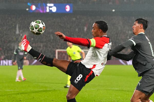 Feyenoord's Quinten Timber kicks the ball next to AC Milan's Tijjani Reijnders during the Champions League playoff first leg soccer match between Feyenoord and AC Milan, at the De Kuip stadium, in Rotterdam, Netherlands, Wednesday, Feb. 12, 2025. (AP Photo/Peter Dejong)