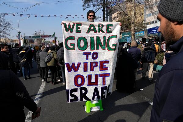 An Iranian demonstrator holds an anti-Israeli banner during a rally commemorating anniversary of 1979 Islamic Revolution that toppled the late pro-U.S. Shah Mohammad Reza Pahlavi and brought Islamic clerics to power, in Tehran, Iran, Monday, Feb. 10, 2025. (AP Photo/Vahid Salemi)