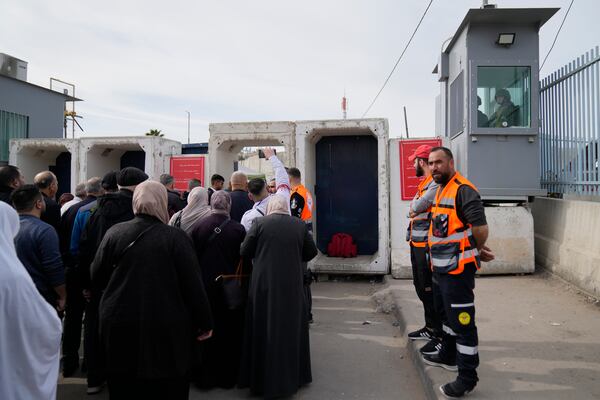 Palestinians cross from the Israeli military Qalandia checkpoint near the West Bank city of Ramallah to Jerusalem, to participate in the Friday prayers at the Al-Aqsa Mosque compound during the Muslim holy month of Ramadan on Friday, March 14, 2025. (AP Photo/Nasser Nasser)