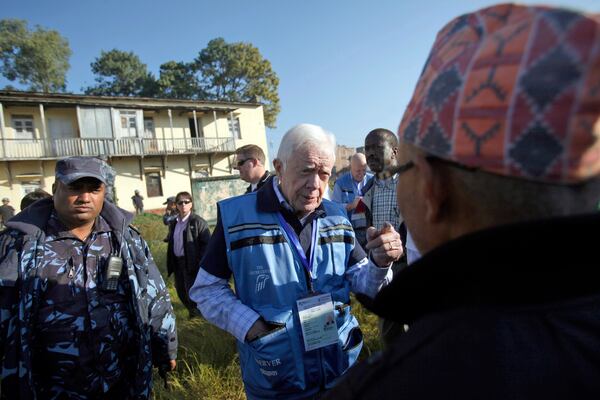 FILE - Former U.S. President Jimmy Carter, center, visits a polling station in Katmandu, Nepal, on Nov. 19, 2013. (AP Photo/Niranjan Shrestha, File)