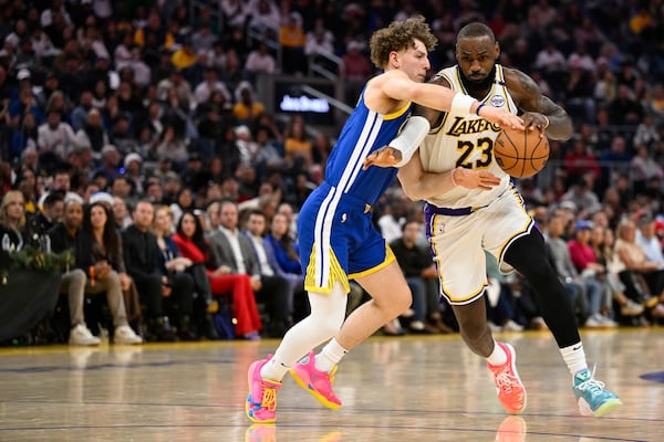 Los Angeles Lakers forward LeBron James (23) drives to the basket against Golden State Warriors guard Brandin Podziemski (2) during the first half of an NBA basketball game Wednesday, Dec. 25, 2024, in San Francisco. (AP Photo/Eakin Howard)