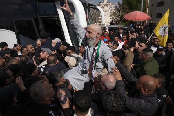 Palestinian prisoners as greeted as they exit a Red Cross bus after being released from Israeli prison following a ceasefire agreement between Israel and Hamas, in the West Bank city of Ramallah, Saturday Feb. 1, 2025. (AP Photo/Mahmoud Illean)