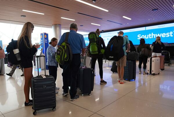 Travelers queue up at the check-in counters for their flights on Southwest Airlines in the main terminal of Denver International Airport Friday, May 23, 2025. (AP Photo/David Zalubowski)