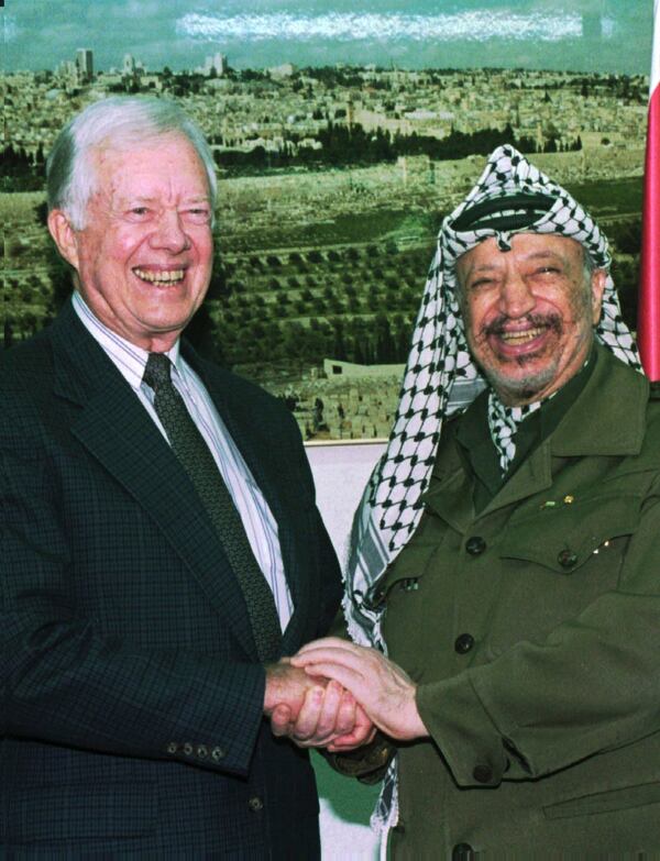 FILE - PLO chairman Yasser Arafat shakes hands with former President Jimmy Carter before their meeting at Arafat's office in Gaza City, on the eve of the first Palestinian elections, Jan. 19, 1996. (AP Photo/Adel Hana, File)