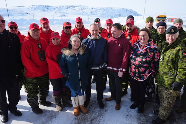 Canada's Defence Minister Bill Blair, front left, Nunavut MLA Janet Brewster, Canada's Prime Minister Mark Carney, Nunavut Premier P.J. Akeeagok, Nunavut Education Minister Pamela Gross, Chief of Defence Staff Gen. Jennie Carignan, along with members of the Canadian Rangers, back left, and members of the Canadian Armed Forces, back right, pose for a photo after an announcement at a Canadian Armed Forces forward-operating location in Iqaluit, Nunavut, Tuesday, March 18, 2025. (Sean Kilpatrick/The Canadian Press via AP)