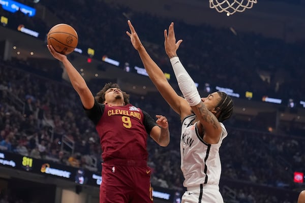 Cleveland Cavaliers guard Craig Porter Jr. (9) shoots as Brooklyn Nets' Trenton Watgford, right, defends in the first half of an NBA basketball game Tuesday, March 11, 2025, in Cleveland. (AP Photo/Sue Ogrocki)