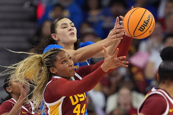 Southern California forward Kiki Iriafen, below, and UCLA center Lauren Betts reach for a loose ball during the second half of an NCAA college basketball game Saturday, March 1, 2025, in Los Angeles. (AP Photo/Mark J. Terrill)