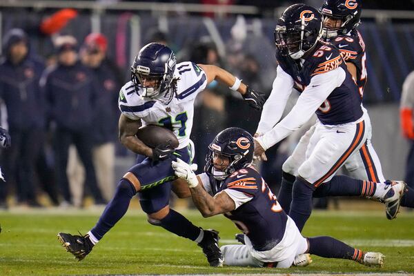 Seattle Seahawks wide receiver Jaxon Smith-Njigba (11) runs with the ball as Chicago Bears safety Jonathan Owens (36) and defensive end Jacob Martin (55) try to stop him during the second half of an NFL football game, Thursday, Dec. 26, 2024, in Chicago. (AP Photo/Erin Hooley)