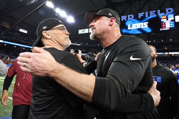 Washington Commanders head coach Dan Quinn, left, and Detroit Lions head coach Dan Campbell, right, talk after an NFL football divisional playoff game, Saturday, Jan. 18, 2025, in Detroit. (AP Photo/Mike Mulholland)