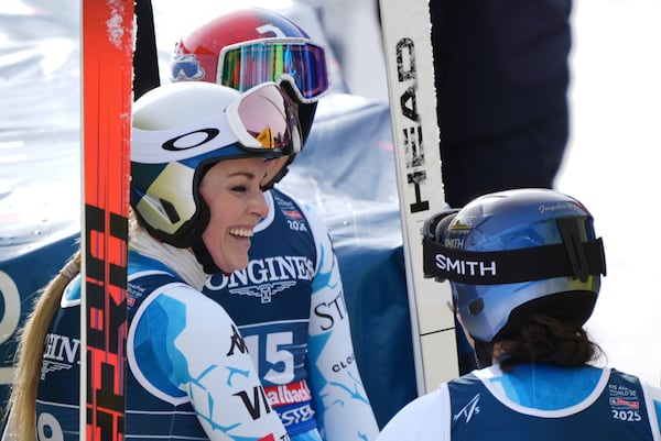 United States' Lindsey Vonn, left, talks to United States' Lauren Macuga and United States' Jacqueline Wiles, right, at the finish area of a downhill run of a women's team combined event, at the Alpine Ski World Championships, in Saalbach-Hinterglemm, Austria, Tuesday, Feb. 11, 2025. (AP Photo/Giovanni Auletta)