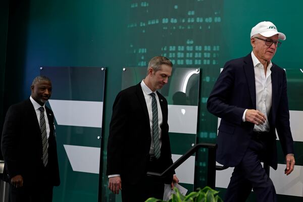 New York Jets owner Woody Johnson, right, leads in new general manager Darren Mougey and head coach Aaron Glenn for a press conference at the NFL football team's training facility on Monday, Jan. 27, 2025, in Florham Park, N.J. (AP Photo/Adam Hunger)