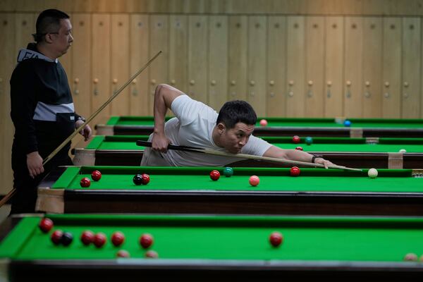 Snooker fan Tong Jianfeng lines up a shot at the Beijing Xinrui Billiard Academy in Beijing, Tuesday, May 6, 2025. (AP Photo/Ng Han Guan)