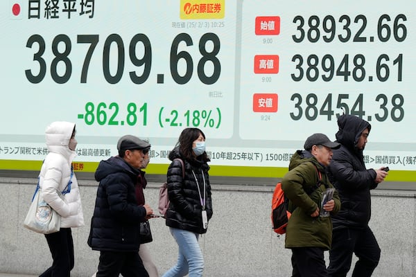 People walk in front of an electronic stock board showing Japan's Nikkei index at a securities firm Monday, Feb. 3, 2025, in Tokyo. (AP Photo/Eugene Hoshiko)