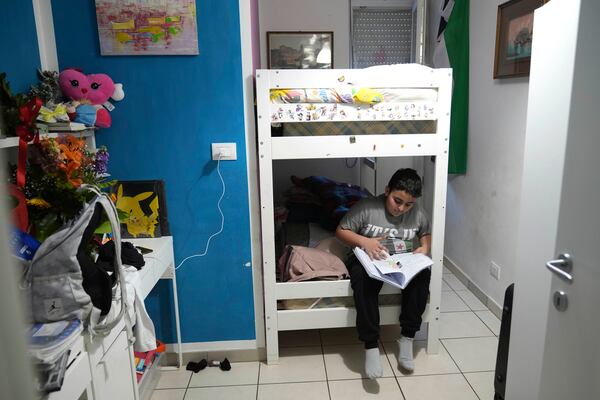 Riad Zaheda reads a book in his room, in Rome, Sunday, March 2, 2025. (AP Photo/Alessandra Tarantino)