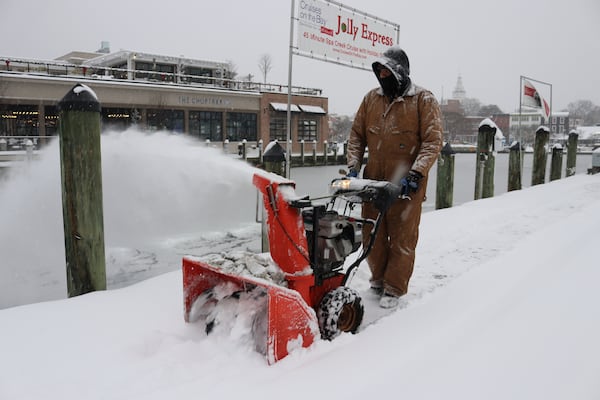 Tony Savage, who works for the city of Annapolis, clears snow along the City Dock in Annapolis, Md., Monday, Jan. 6, 2025. (AP Photo/Brian Witte)