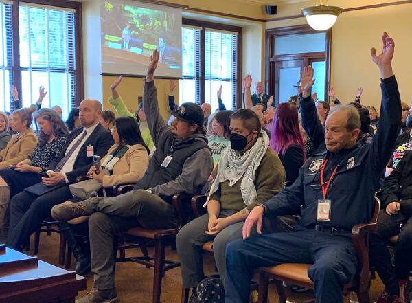 Union members in public service professions across Utah raise their hands to speak in opposition to a bill banning public sector collective bargaining, Thursday, Jan. 23, 2025, at the Capitol Building in Salt Lake City. (AP Photo/Hannah Schoenbaum)