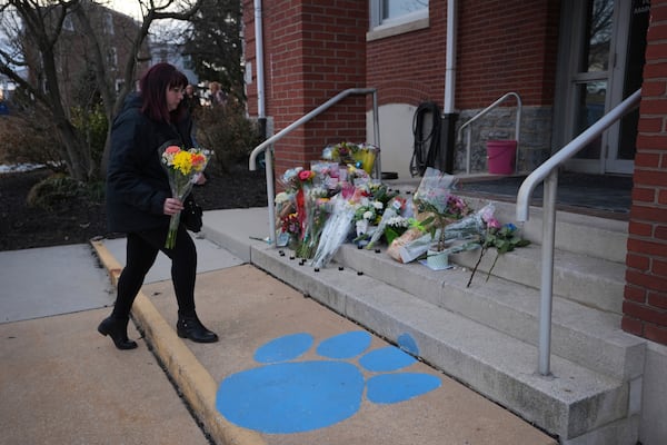 People place flowers in front of the West York Police Department after a police officer was killed responding to a shooting at UPMC Memorial Hospital in York, Pa. on Saturday, Feb. 22, 2025. (AP Photo/Matt Rourke)