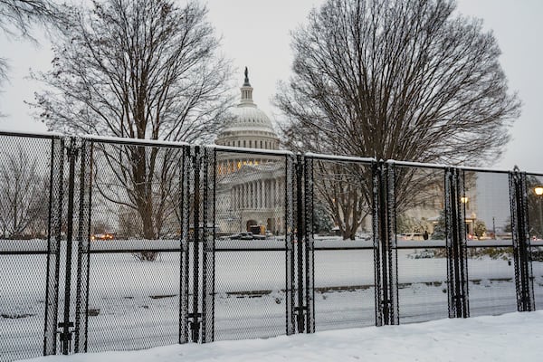 Security fencing surrounds Capitol Hill as snow blankets the region ahead of a joint session of Congress to certify the votes from the Electoral College in the presidential election, in Washington, Monday, Jan. 6, 2025. (AP Photo/J. Scott Applewhite)