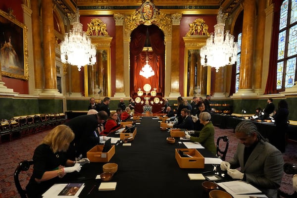 Wardens sit at a table to check the quality of coins during the "Trial of the Pyx,'' a ceremony that dates to the 12th Century in which coins are weighed in order to make certain they are up to standard, at the Goldsmiths' Hall in London, Tuesday, Feb. 11, 2025.(AP Photo/Frank Augstein)