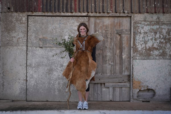 Christina Louka, 16, poses for a portrait, dressed in animal skins and heavy bronze bells, as part of carnival celebrations in Distomo, a village in central Greece, on Monday, March 3, 2025. (AP Photo/Petros Giannakouris)