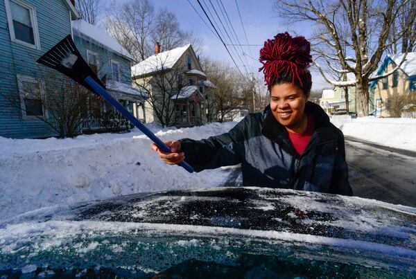 Trinity Jackson uses an ice scraper to clean her rear window on Monday, Feb. 17, 2025, Brattleboro, Vt., after a winter storm on Sunday. (Kristopher Radder/The Brattleboro Reformer via AP)