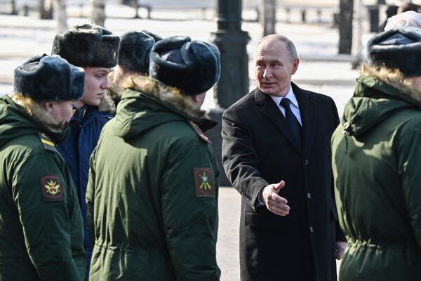 Russian President Vladimir Putin speaks with servicemen during a wreath-laying ceremony at the Tomb of the Unknown Soldier, near the Kremlin Wall during the national celebrations of the "Defender of the Fatherland Day" in Moscow, Russia, Sunday, Feb. 23, 2025. (Sergei Bobylev, Sputnik, Kremlin Pool Photo via AP)