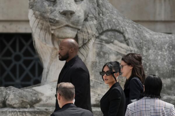 Kim Kardashian, center, arrives to testify regarding a robbery of millions of dollars in jewels from her Paris hotel room in 2016, in Paris, Tuesday, May 13, 2025. (AP Photo/Aurelien Morissard)