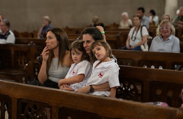 Lucia Carlevaro embraces her daughters while attending a mass for Pope Francis' health in Buenos Aires, Argentina, Wednesday, Feb. 19, 2025. (AP Photo/Rodrigo Abd)