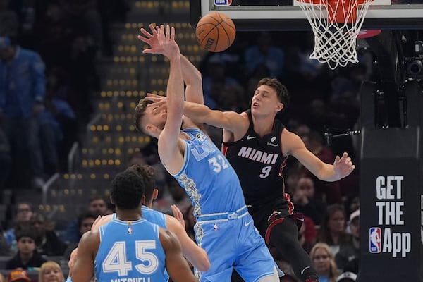 Miami Heat guard Pelle Larsson (9) fouls Cleveland Cavaliers forward Dean Wade (32) in the first half of an NBA basketball game Wednesday, March 5, 2025, in Cleveland. (AP Photo/Sue Ogrocki)