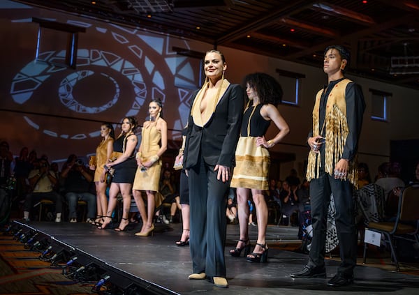 Designer Randi Nelson takes the stage after her runway show at the 2025 Native Fashion Show, Friday, May 9, 2025, in Santa Fe, N.M. (AP Photo/Roberto E. Rosales)