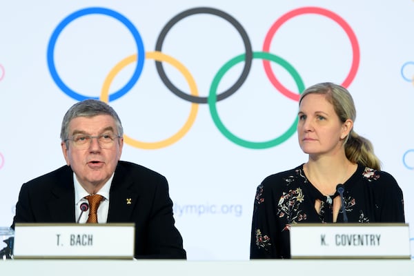 FILE - International Olympic Committee (IOC) president Thomas Bach, left, and IOC member and former swimmer Kirsty Coventry, right, speak during a press conference after the executive board meeting of the IOC, at the Olympic House, in Lausanne, Switzerland, Thursday, Jan. 9, 2020. (Laurent Gillieron/Keystone via AP, File)