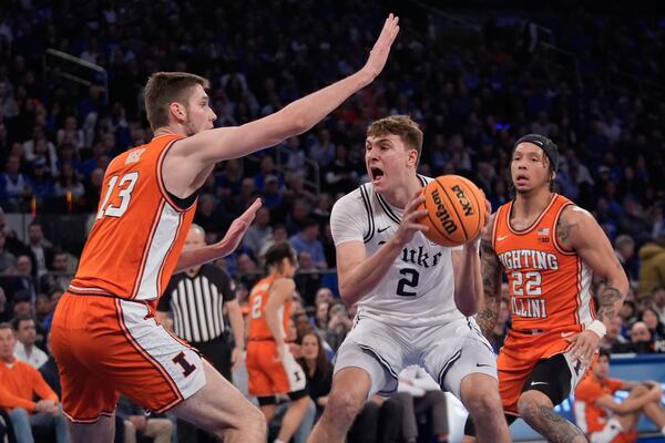 Illinois' Tomislav Ivisic (13) and Tre White (22) defend Duke's Cooper Flagg (2) during the first half of an NCAA college basketball game Saturday, Feb. 22, 2025, in New York. (AP Photo/Frank Franklin II)