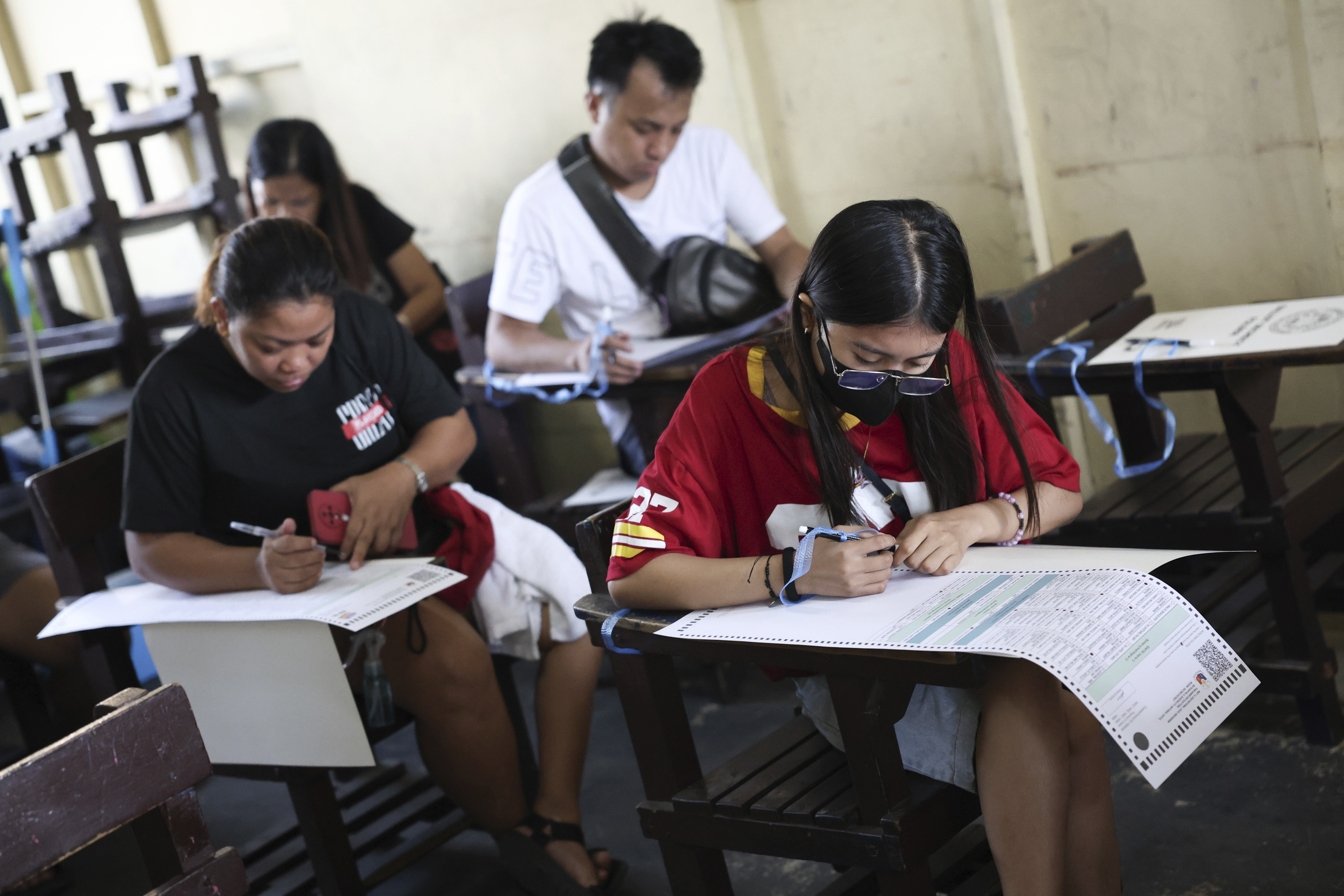 Voters cast their ballots at a polling station in Quezon City, Philippines, Monday, May 12, 2025. (AP Photo/Basilio Sepe)