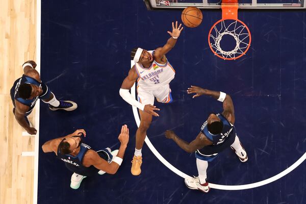 Oklahoma City Thunder guard Shai Gilgeous-Alexander, middle, shoots the ball against the Minnesota Timberwolves during the first half of Game 3 of the Western Conference finals of the NBA basketball playoffs Saturday, May 24, 2025, in Minneapolis. (AP Photo/Matt Krohn)