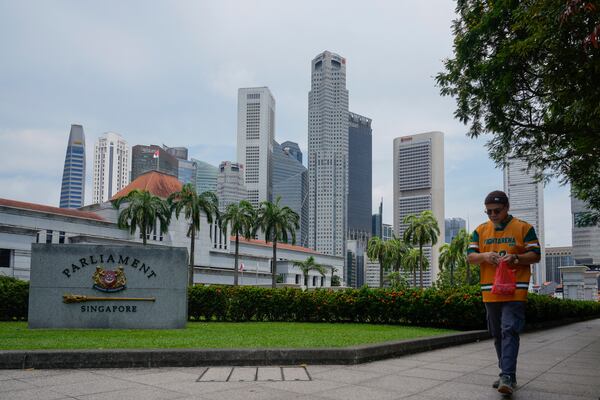 Pedestrian walks in front of the parliament building in Singapore, Friday, May 2, 2025. (AP Photo/Vincent Thian)