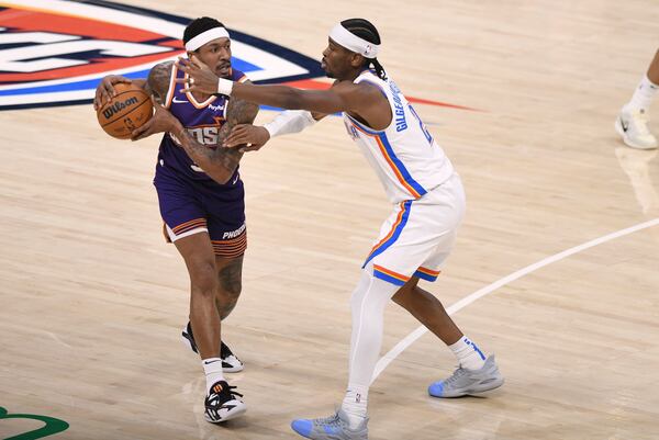 Phoenix Suns guard Bradley Beal, left, keep the ball away from Oklahoma City Thunder guard Shai Gilgeous-Alexander, right, during the first half of an NBA basketball game, Wednesday, Feb. 5, 2025, in Oklahoma City. (AP Photo/Kyle Phillips)