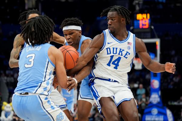 North Carolina guard Elliot Cadeau, from left, forward Ven-Allen Lubin and Duke guard Sion James battle for a loose ball during the first half of an NCAA college basketball game in the semifinals of the Atlantic Coast Conference tournament, Friday, March 14, 2025, in Charlotte, N.C. (AP Photo/Chris Carlson)