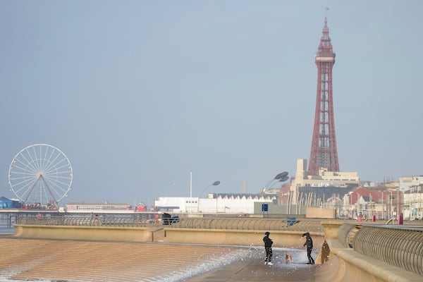 Dog walkers brave the wind as Storm Eowyn hits the country in Blackpool, England, Friday, Jan. 24, 2025.(AP Photo/Jon Super)