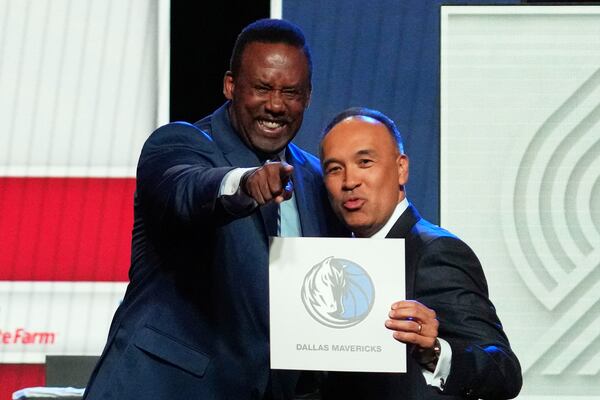 Dallas Mavericks' Rolando Blackman, left, and NBA Deputy Commissioner Mark Tatum, right, pose for photos after Tatum announced that the Mavericks had won the first pick in the NBA basketball draft lottery in Chicago, Monday, May 12, 2025. (AP Photo/Nam Y. Huh)