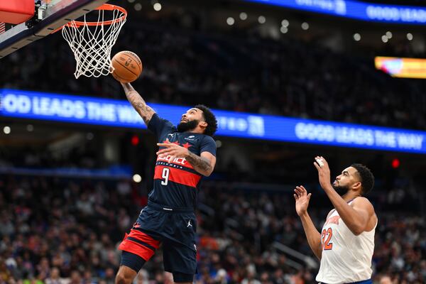 Washington Wizards forward Justin Champagnie (9) dunks the ball as New York Knicks center Karl-Anthony Towns trails during the first half of an NBA basketball game, Saturday, Dec. 28, 2024, in Washington. (AP Photo/Terrance Williams)