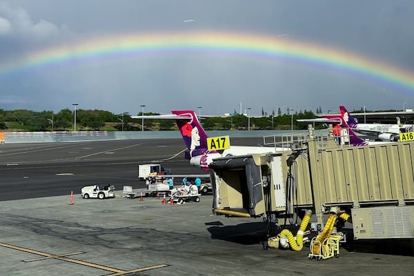 In this image taken through a window, a rainbow appears in the sky on Dec. 23, 2023, in Honolulu. (AP Photo/Audrey McAvoy)