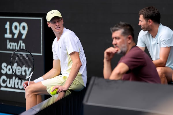 Jannik Sinner of Italy talks with his coaching staff as repairs are made too the net during his fourth round match against Holger Rune of Denmark at the Australian Open tennis championship in Melbourne, Australia, Monday, Jan. 20, 2025. (AP Photo/Asanka Brendon Ratnayake)